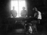 Suljulassa  Suljulan pirtissä Valfrid Valden (1888 - 1964) istuu, Edla Valden ja Aino Valden leipovat.