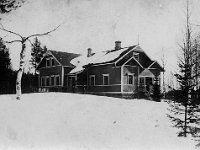 Huokola(14)  Vekkulan koulu, jonka lumiselle pihalle on kokoontunut koululaisia opettaja Kaarlo Vilhelm Hongiston (1882 - 1971) kanssa, päädyn rappusilla mahdollisesti hänen vaimonsa opettaja Edla Hongisto (o.s. Suomalainen, k. 1950).