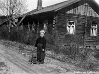 Image27  Seppo Ilmonen (s. 12.4.1952) Juokslahti - Vekkula -kylätiellä eli Vekkulantiellä isänsä tekemän leluauton kanssa, takana lehdetön pensasaita ja Sepon kodin Killilän vanha talo (purettu n. 1962).