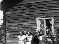 Image41  Leuhulan talon pirtinpäädyn edessä vasemmalta tunnistamaton nainen, Siiri Dagmar Mäki (o.s. Tähtinen, myöhemmin Martikainen, 12.9.1907 - 1999?), Siirin sisko Katri Hienola (o.s. Tähtinen) eli Kopoon Kaisa keskellä esiliina päällä, tummassa takissa Katrin ja Siirin serkku Elvi Kauranen (o.s. Tähtinen, 2.5.1921 - 21.2.1999) Koivulasta, ja Siirin sodassa kaatuneen aviomiehen vanhemmat Onni Eemeli Mäki ja Senja Mäki (o.s. Hannula?) Ylöjärven Lielahdesta. Ikkunan ääressä sisällä useita henkilöitä - oikealla Katrin ja Siirin täti, joko Katrin kasvattiäiti Ida Oksanen tai Selma Järvinen Hirvimäen Kuoppalasta. (molemmat o.s. Tähtinen, lapsuudessa sukunimi Leuhula) Etualalla unikon siemenkotia.