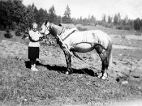 palvia(12)  Anna Suominen pitelee valjastettua hevosta suitsista.
