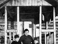 peltola(58)  Ida Hakanen (o.s. Lehtinen, 20.3.1902 - 21.2.1955) sekä  vanhempi poikansa Mikko Hakanen (vasemmalla) ja nuorempi poikansa Erkki Hakanen (oikealla) seisovat lumessa puurakennuksen edessä. Molemmilla pojilla jaloissaan huopatossut