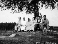 pullila(61)  Vasemmalta kauppiaspariskunta Kalle (22.8.1889 - 6.3.1968) ja Tyyne Oksala (10.2.1894 - 23.5.1974), Tyynen äiti Liida (vai Liita? vrt. kuva 0169) Järvinen, Erika Lepola, Oksaloiden poika Eero (22.8.1889 - 6.3.1968) sekä Keijo Bäcklund istuvat penkillä puun varjossa
