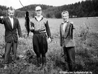 taarala(68)  Keskellä Reino Kauranen (2.6.1926 - 18.1.1965) esittelee pyytämäänsä isoa haukea, sukulaispojat Reijo ja Raimo pienempiä kalansaaliita.